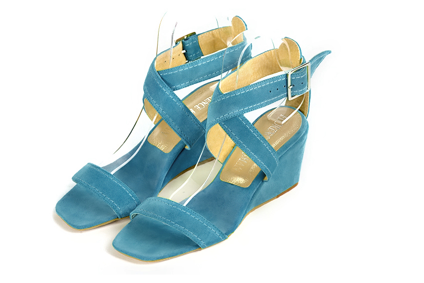 Peacock blue elegant sandals with cross straps across the instep, fully open. Square toe. Medium wedge heels.